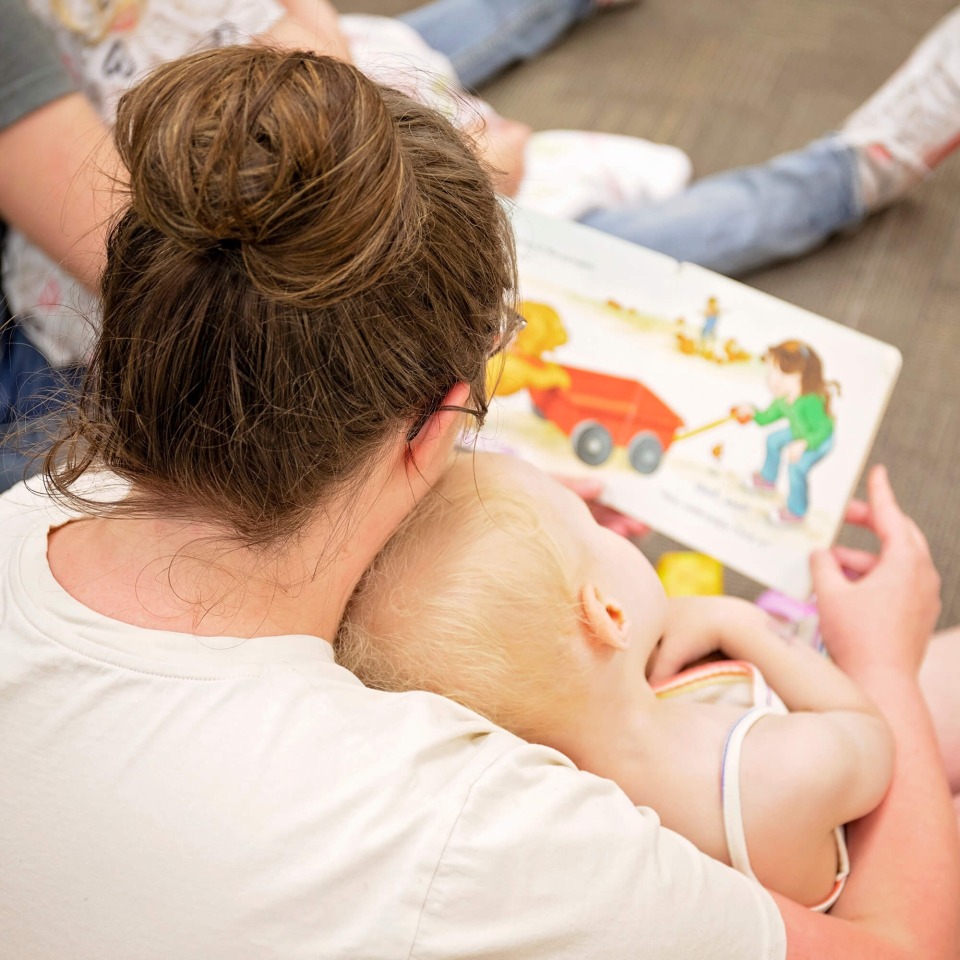 Van Buren County Preschool staff member reading with a young child.